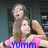 Pixelated static image of two figures in a close embrace, one in pink and blue clothing, against a dark background.