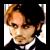 Pixelated close-up of a person with light brown hair, wearing dark clothing and white collar, against a bright background.
