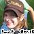 Pixelated image of a person with brown hair wearing a light-colored head covering, smiling against green background with text "Smiley Patrick" at bottom.