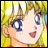 Pixelated anime-style close-up of a character with blonde hair and blue eyes, smiling with mouth open, next to stylized text on black background.