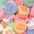 Pixelated image of colorful heart-shaped candies with text overlay reading 'these hearts are LIARS!!' in purple block letters.