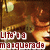 Pixelated image with warm brown and orange tones showing a stylized figure in motion against a blurred background, overlaid with red text reading "Lita'ya maquerade".