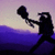 Silhouette of a figure holding a large object against a gradient background transitioning from purple to blue.