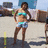 A pixelated image of a person in a bikini top and shorts standing outdoors, with a text overlay changing from 'HeY' to gray.