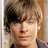 A static image with a bright pink background, featuring a pixelated photo of a person with light brown hair and a gray jacket, alongside blue text reading "Zach Efron is mine so.... back off!".
