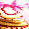 Stacked cookies with red icing dots and a pink ribbon bow on top, viewed from above.