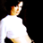 Pixelated figure in white shirt and dark pants with orange hair, viewed from behind against black background, head tilted upward.