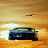 A pixelated image shows a dark vehicle with blue accents against a gradient background of yellow and brown tones.