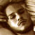 Pixelated static image of a person's face with brown hair and light skin tone, rendered in low-resolution 256x256 pixels with visible dithering and color blending.