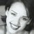 Pixelated grayscale portrait of a smiling person with closed eyes and dark hair against a light background.