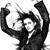 Black-and-white pixelated icon shows a figure with raised arms holding a circular object, rendered in low-resolution style with visible dithering.
