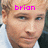 A pixelated image of a person with light hair and blue eyes, wearing a white shirt and dark jacket, with pink text above the head.