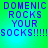 Green and blue gradient background with purple pixelated text reading "DOMENIC ROCKS YOUR SOCKS!!!!!" in four identical