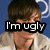 A pixelated image of a person with brown hair wearing a light-colored jacket, overlaid with black text reading "I'm ugly" against a blue background.