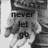 Black-and-white pixelated image with text 'never let go' overlaid on a blurred background of indistinct shapes.