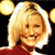 Pixelated image of a person with blonde hair wearing a red top against a dark background with two yellow circular shapes on the left and right edges.