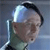 Pixelated close-up of a person wearing a light blue helmet and dark green clothing against a gradient background.