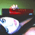 Pixelated image of a character with white hair and blue eyes holding a red object against a green background.