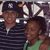 Two people in a pixelated image; one wears a striped shirt and dark cap, the other a green top with dark hair, both facing forward.