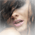 Pixelated close-up of a person's face with dark hair, light skin, and pink lips, showing a slight smile against a blurred background.