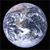 A pixelated circular image of a moon with visible craters and light variations against a black background.