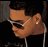 Pixelated static image of a person's profile wearing sunglasses and earphones with visible facial features, dark hair, and a black background.