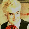 A static icon shows a person with light blonde hair, wearing a dark vest over a white shirt and red cravat, with partial red text and a red heart symbol visible on the right.