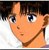 Pixelated close-up of a character with light brown skin, dark brown hair, blue eyes, and a neutral expression wearing a white shirt.