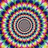 A pixelated circular pattern with concentric rings of multicolored pixels surrounding a gray center, paired with orange text on black background.