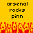 Yellow background with black text reading 'arsenal rocks pinn' repeated twice, and a red-orange pixelated crowd at the bottom.
