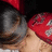Two figures in red hats and gray clothing embrace closely against a dark background.