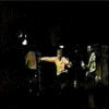 Animated sequence of a person in a light-colored shirt performing dynamic dance moves against a dark background with other figures.