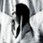 Black-and-white pixelated image of a person with long dark hair covering their face, next to red pixelated text on a black background.