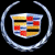 A pixelated logo featuring a shield with red, blue, yellow, and black sections encircled by a silver ring on a black background, next to green text reading 'Original Icons .com' on dark green.