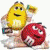 Two M&M characters, yellow and red, stand side-by-side with a background of colorful M&Ms; text below reads "Chocolate Is Better in Color!".