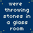 Blue background with yellow dots and repeated white text reading 'were throwing stones in a glass room'