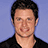 Pixelated image of a person with short dark hair and light skin wearing a black shirt against a blue background, overlaid with red text elements.