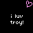 A static pixel art image with a black background, pink heart symbol at top center, and white text reading "i luv troy!" in two identical vertical