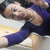 Pixelated image of a person in blue clothing lying on a light-colored surface with dark hair and visible arm.