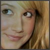 Close-up of a person's face with light brown hair, brown eyes, and a slight smile, cropped to show only the upper face and hair.