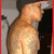 A pixelated figure with a rounded head and broad shoulders stands in profile, facing right, against a dark background with light-colored vertical elements.