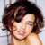 Pixelated close-up of a person with short brown hair, light skin tone, and closed eyes against a pale background.