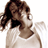 Static pixelated image of a person with brown hair and light skin wearing a white top, viewed from the side against a plain background.