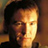 Pixelated close-up of a person's face with dark hair, warm lighting, and blurred background in brown and orange tones.