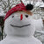 A pixelated snowman icon with a red hat, black top hat, red nose, and smiling mouth against a blurred background.