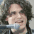 A four- shows a person with curly hair holding a microphone, another person in profile, and text reading 'john mayer' on a gray background