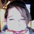 Pixelated close-up of a character with closed eyes, dark hair, and a light-colored garment with pink accents, set against a blurred background.