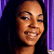 Pixelated close-up of a smiling person with dark hair against a purple and dark background, rendered in low-resolution digital style.