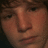 Pixelated close-up of a person's face showing nose, eyes, and mouth with brown hair visible at top edge.