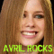 A pixelated image of a person with long light brown hair, showing two side-by-side expressions: one with teeth visible and another with mouth closed.